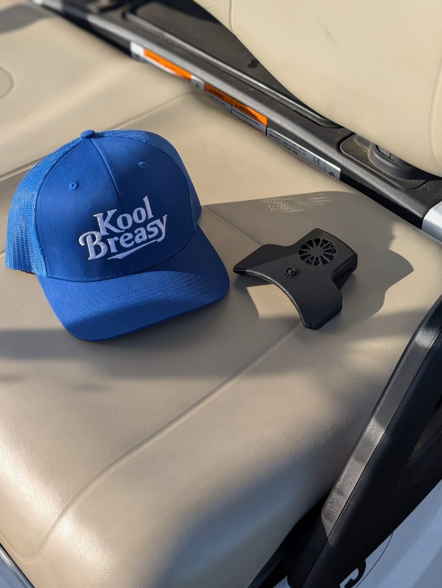 Kool Breasy cap and fan unit resting on a golf cart seat